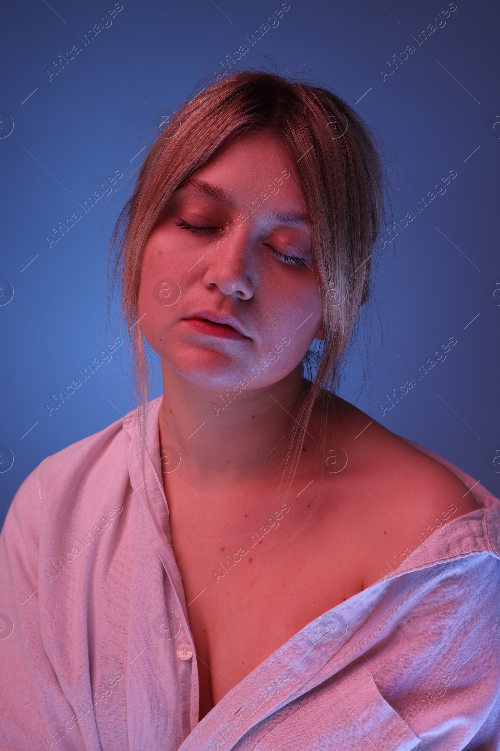 Photo of Portrait of beautiful young woman on color background with neon lights