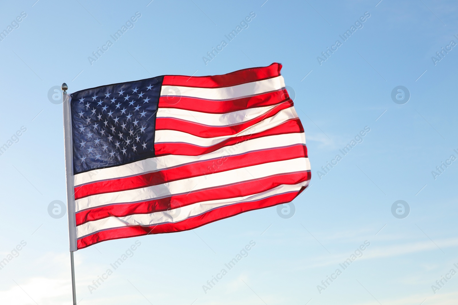 Photo of American flag fluttering outdoors on sunny day