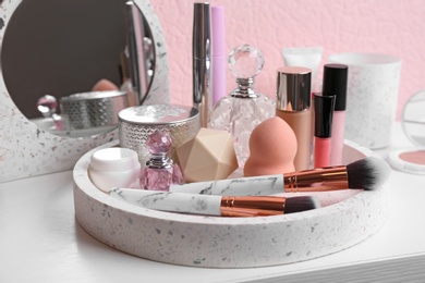 Set of luxury makeup products and perfumes on dressing table