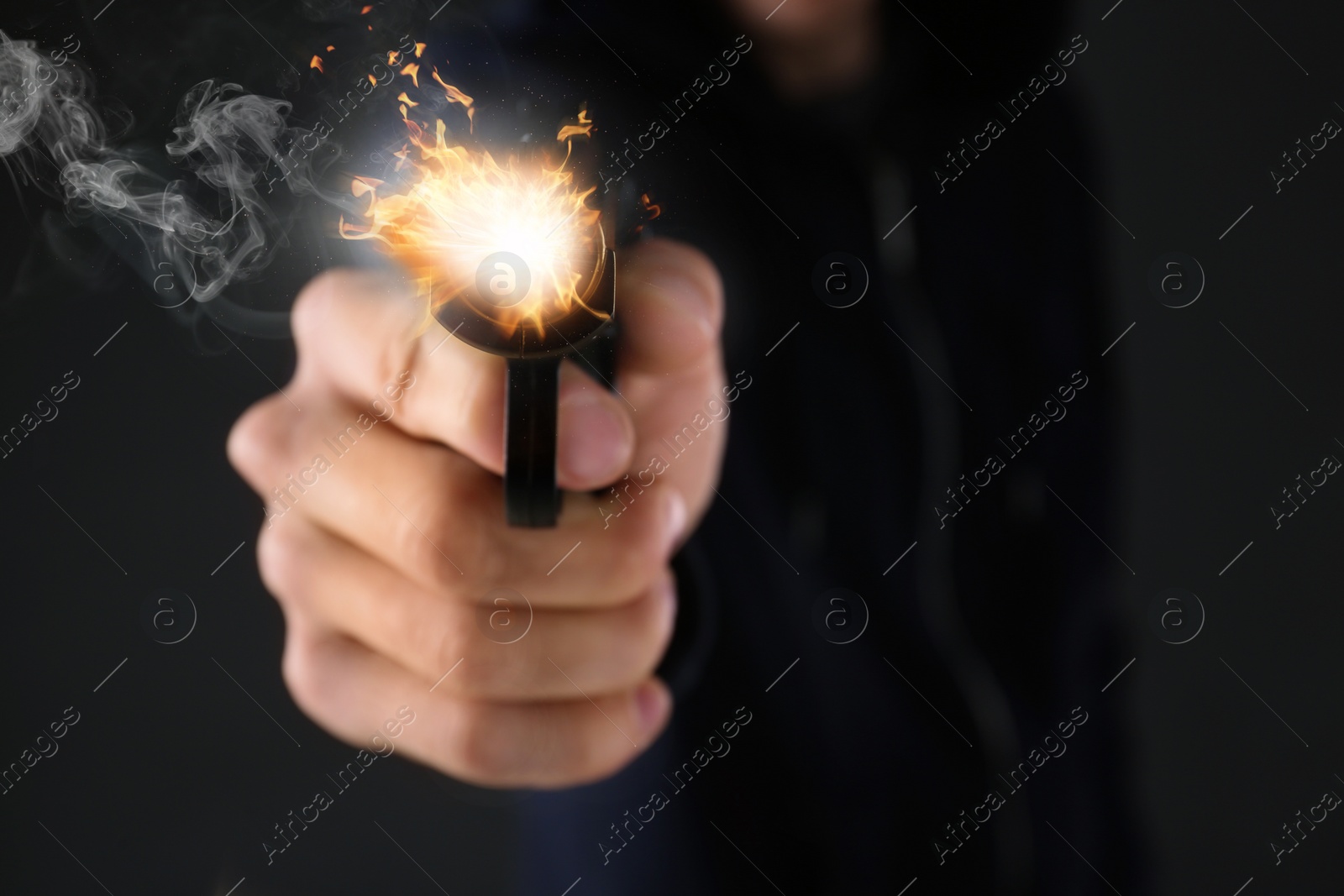 Image of Man shooting handgun on black background, closeup