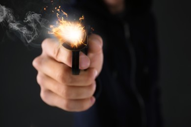 Man shooting handgun on black background, closeup