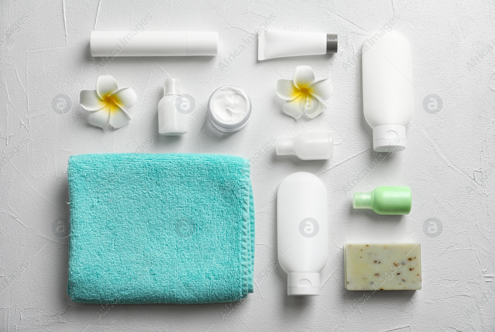 Photo of Flat lay composition with spa cosmetics and towel on white background