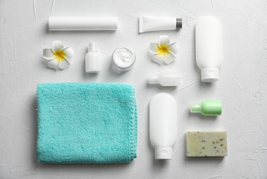 Photo of Flat lay composition with spa cosmetics and towel on white background