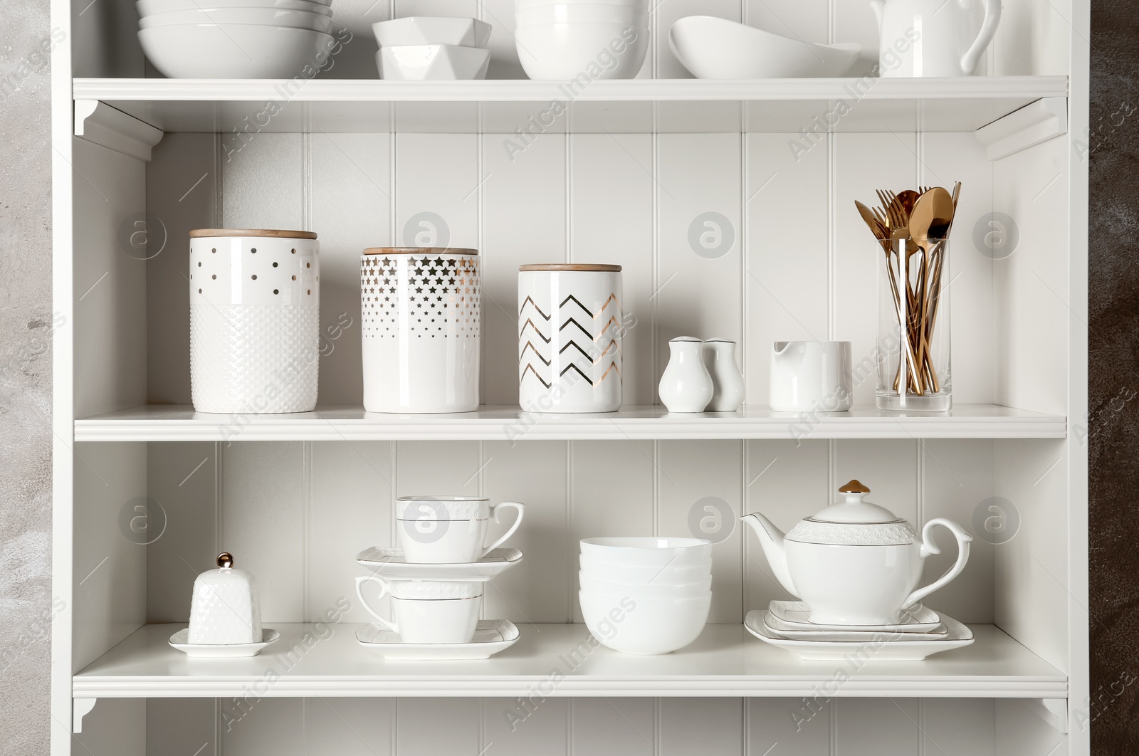 Photo of White shelving unit with set of dishware