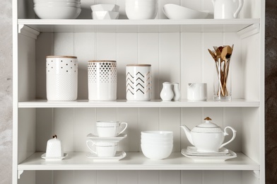 Photo of White shelving unit with set of dishware