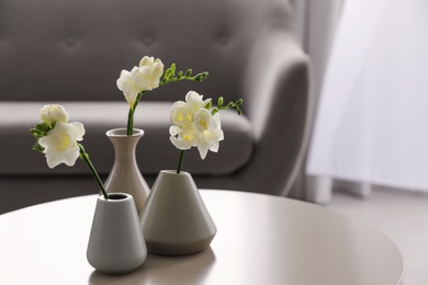 Beautiful spring freesia flowers on white table in room