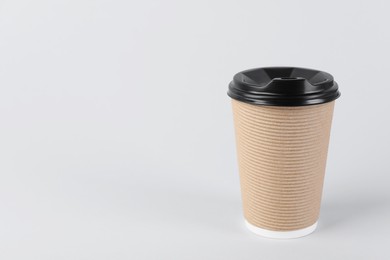 Photo of Paper cup with plastic lid on light background, space for text. Coffee to go