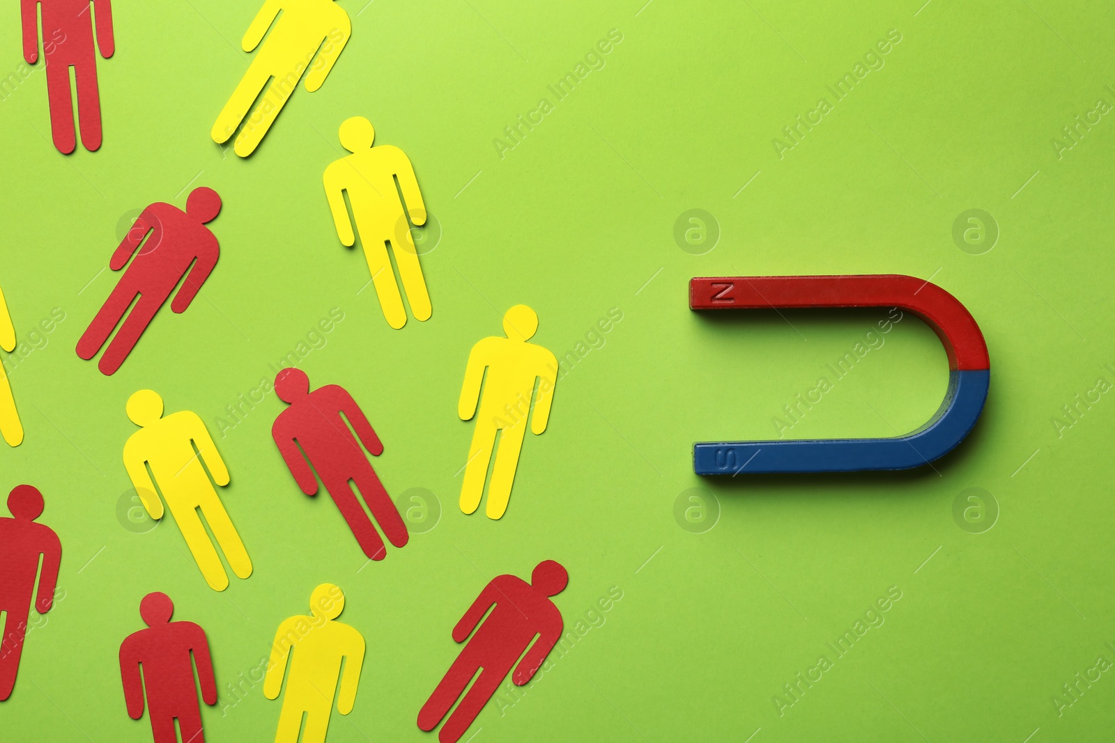 Photo of Magnet attracting paper people on color background, flat lay. Marketing concept