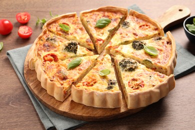 Delicious homemade vegetable quiche on wooden table