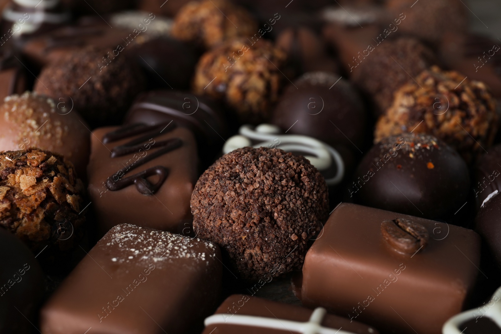 Photo of Different delicious chocolate candies as background, closeup