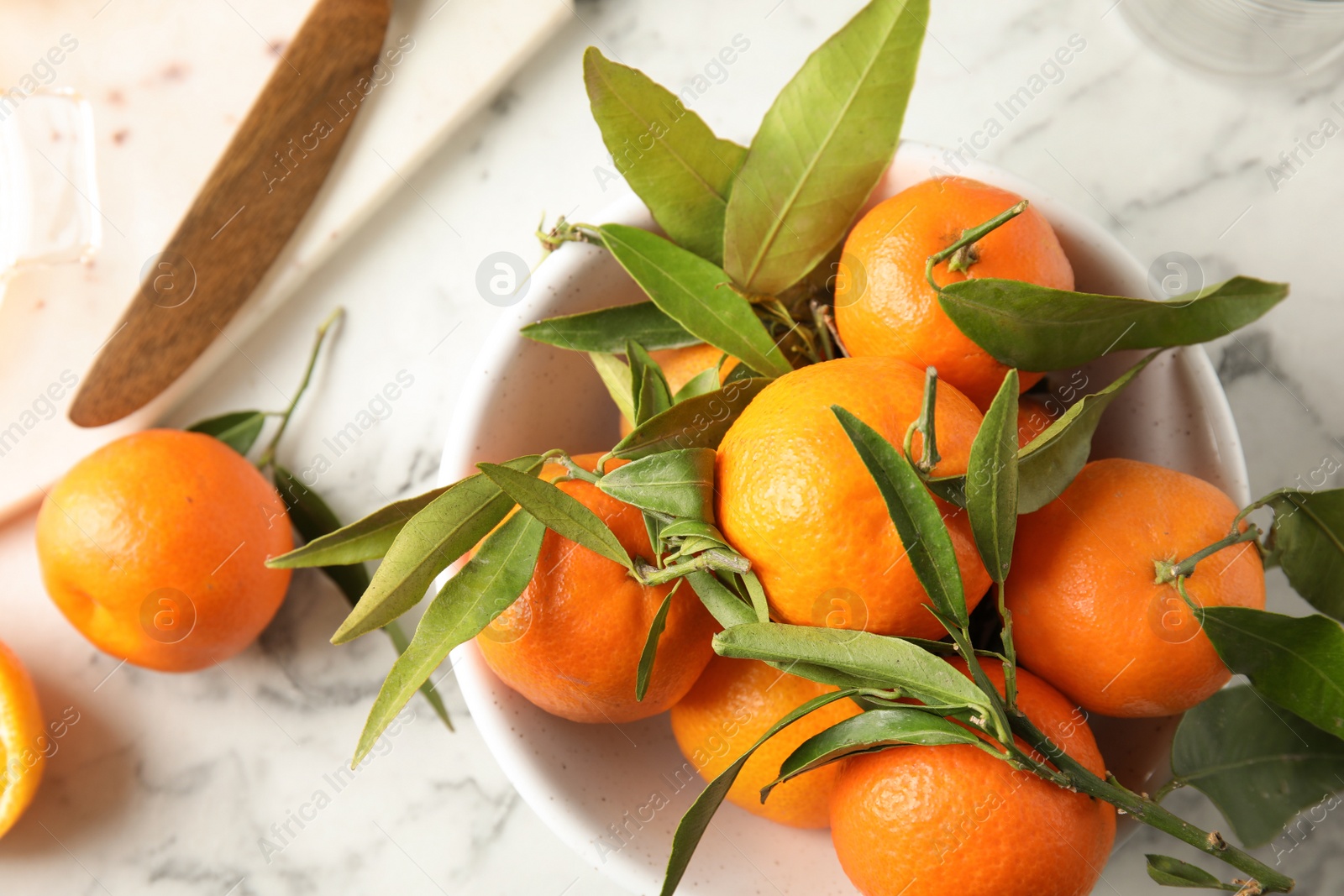 Photo of Bowl with ripe tangerines on table, top view