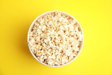 Photo of Tasty pop corn on yellow background, top view