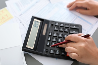 Young female calculating taxes at table, closeup