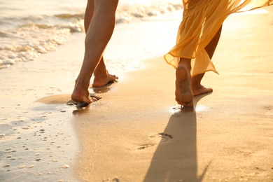 Photo of Couple walking together on beach, closeup view