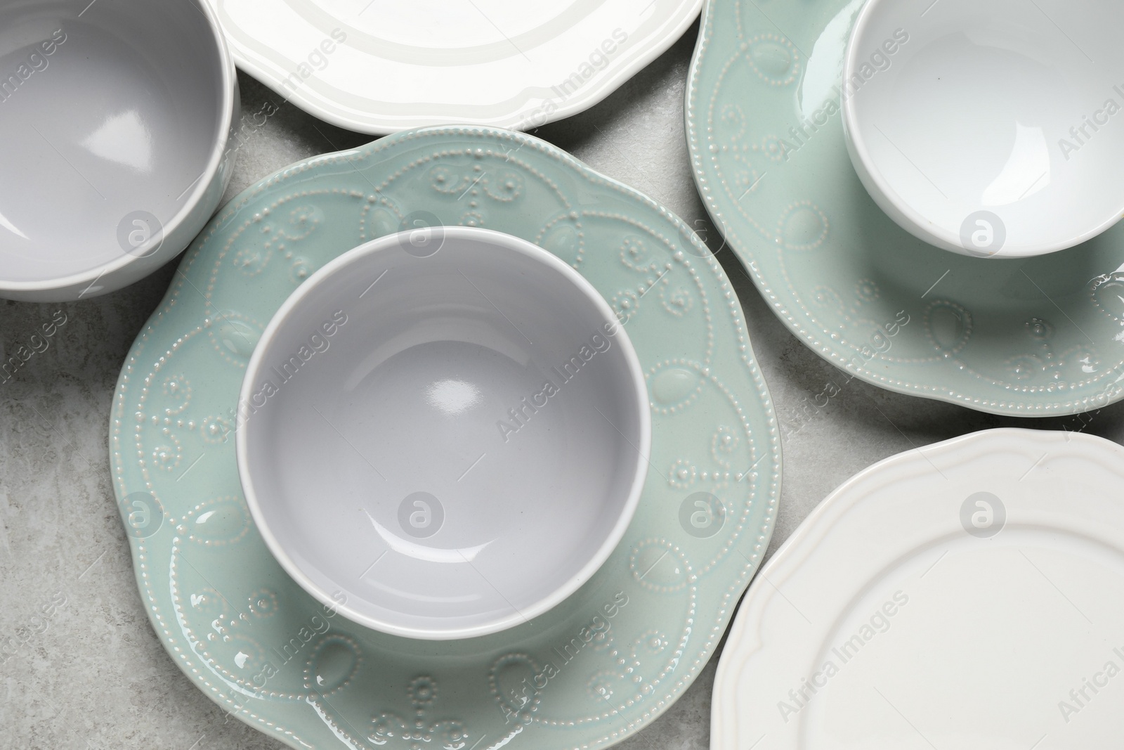 Photo of Beautiful ceramic dishware on light grey table, flat lay