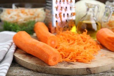 Cooking delicious sauerkraut soup. Fresh chopped carrot on wooden table, closeup