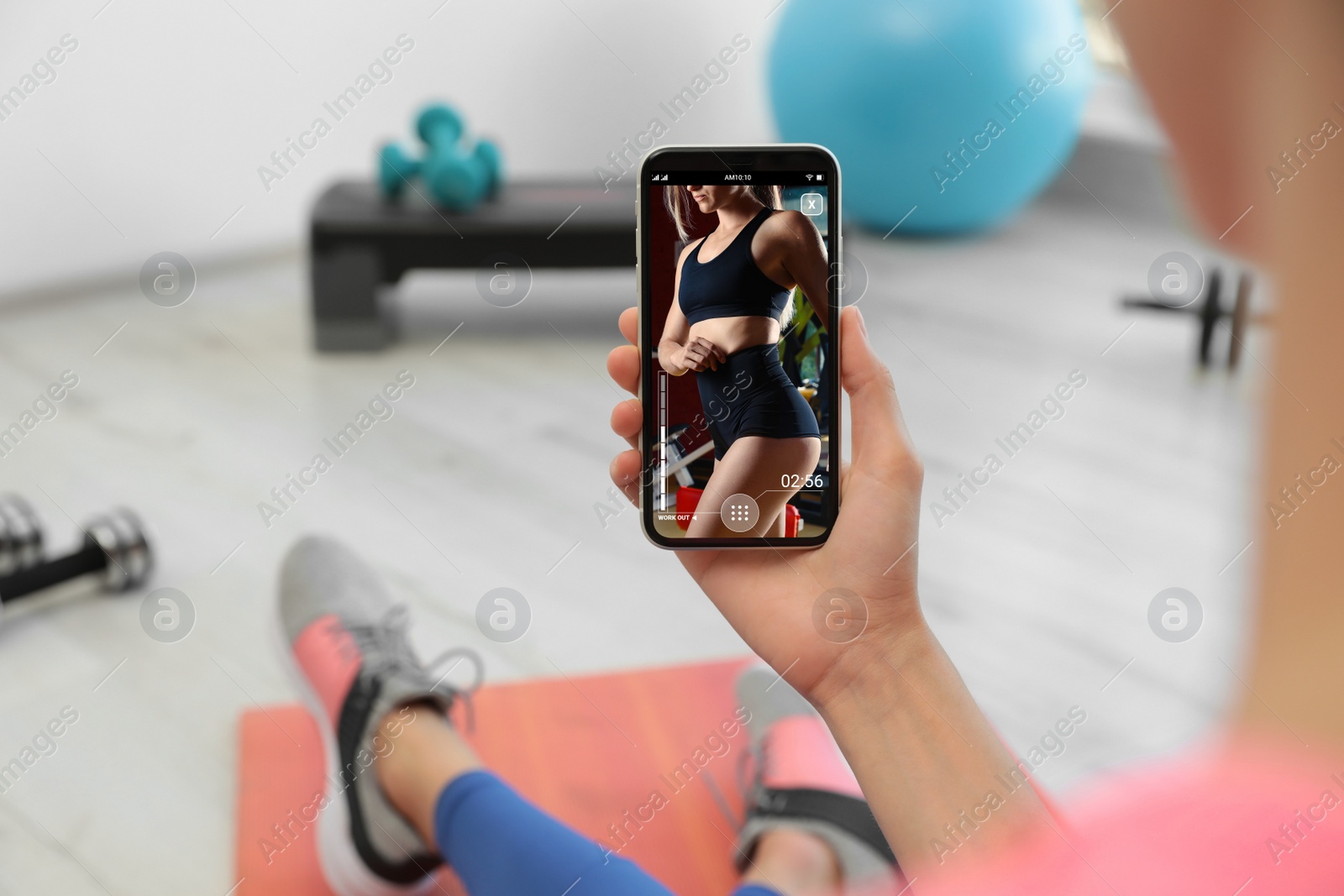 Image of Woman having workout with personal trainer via smartphone at home, closeup