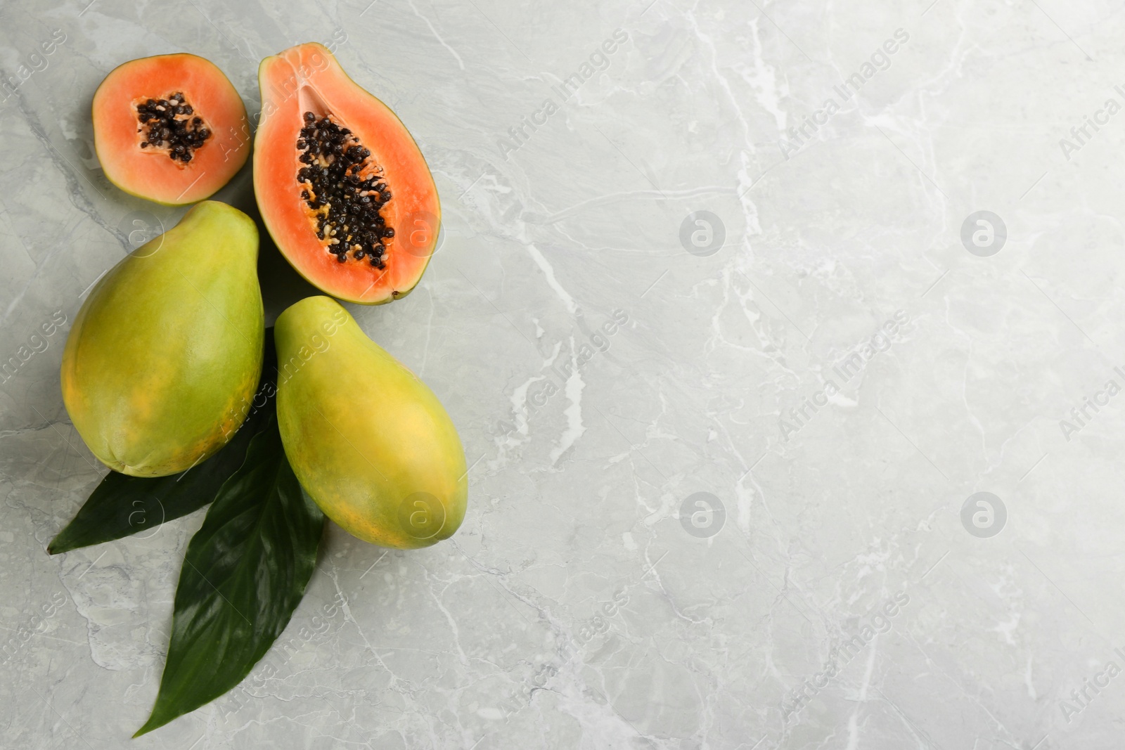 Photo of Fresh ripe papaya fruits on light grey table, flat lay. Space for text