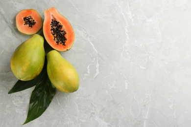 Fresh ripe papaya fruits on light grey table, flat lay. Space for text