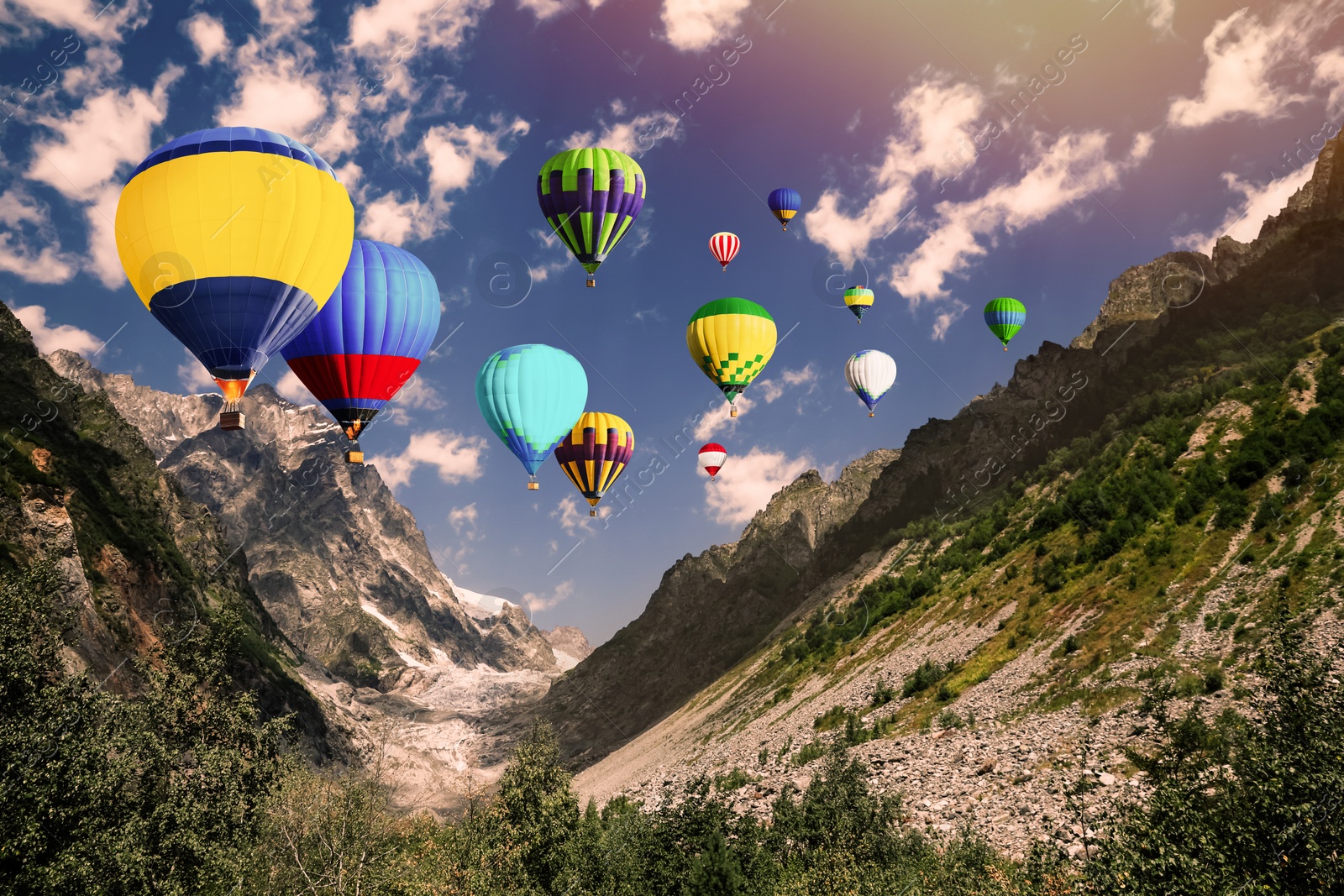 Image of Bright hot air balloons flying over mountains