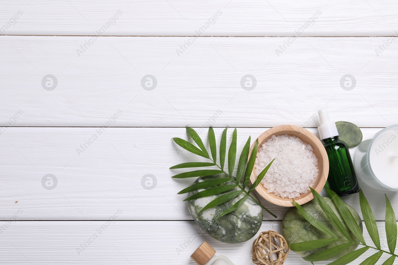 Photo of Flat lay composition with candle and different spa products on white wooden table. Space for text