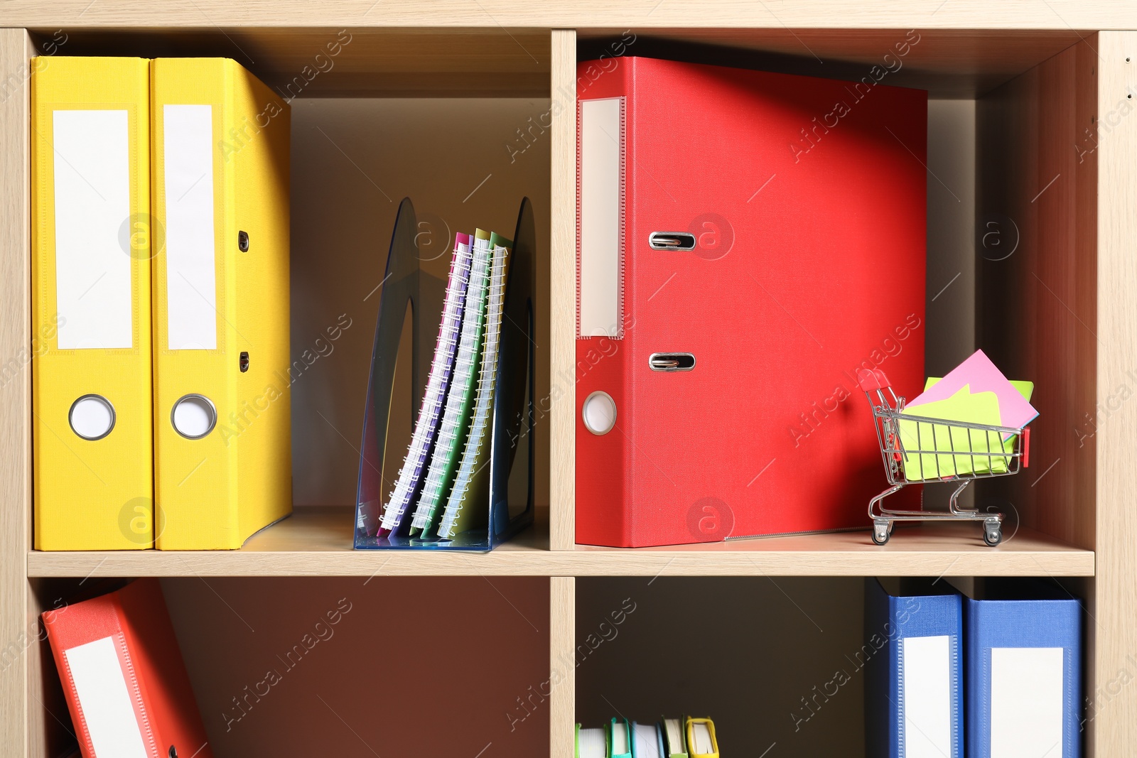 Photo of Colorful binder office folders and other stationery on shelving unit