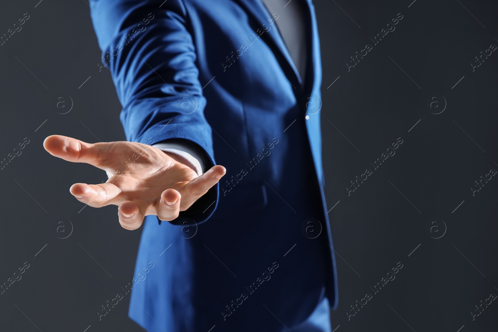 Photo of Businessman holding something in hand on dark background