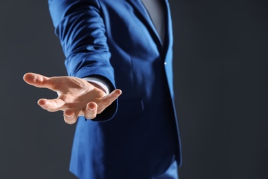 Photo of Businessman holding something in hand on dark background