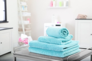 Soft bath towels on table against blurred background, space for text