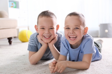 Photo of Portrait of cute twin brothers on floor in living room
