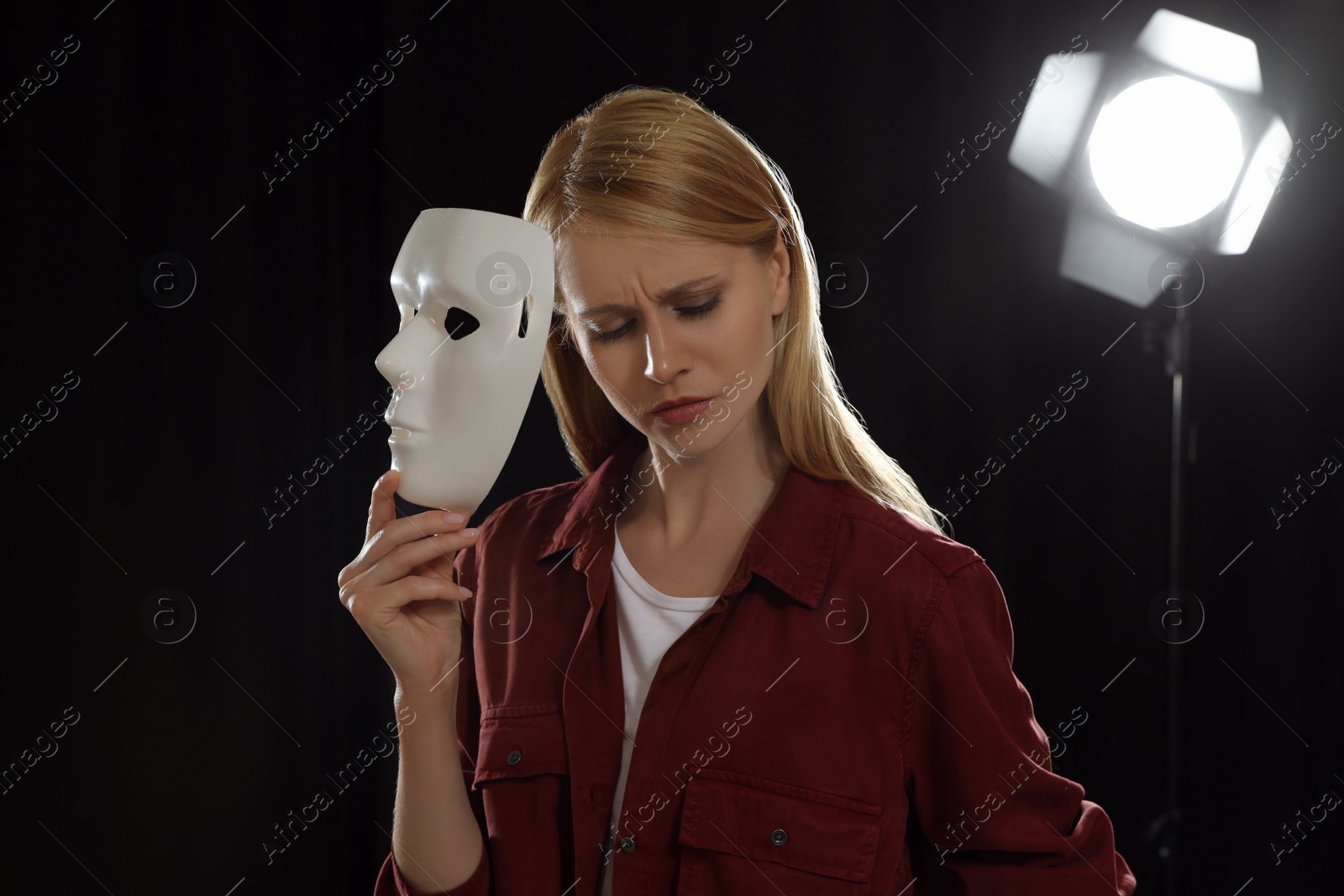 Photo of Professional actress rehearsing with mask on stage in theatre