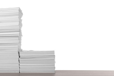 Photo of Stacks of paper sheets on wooden table against white background. Space for text