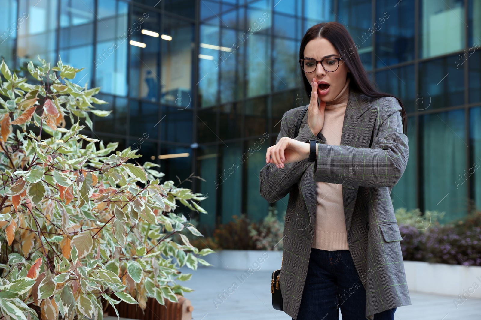 Photo of Emotional woman checking time on watch outdoors. Being late concept