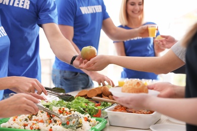 Volunteers serving food to poor people, closeup