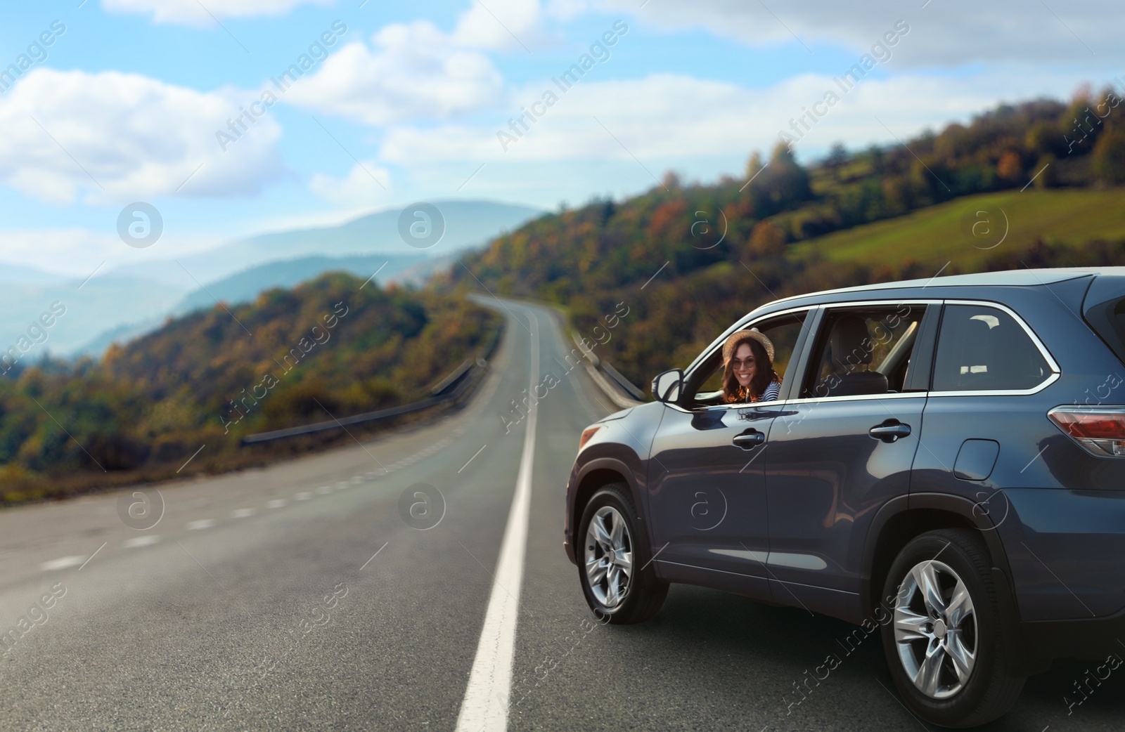 Image of Road trip. Young beautiful woman in car on asphalt highway, space for text  