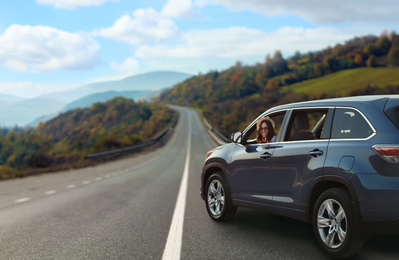 Image of Road trip. Young beautiful woman in car on asphalt highway, space for text  