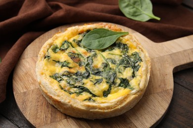 Photo of Delicious pie with spinach on wooden table, closeup