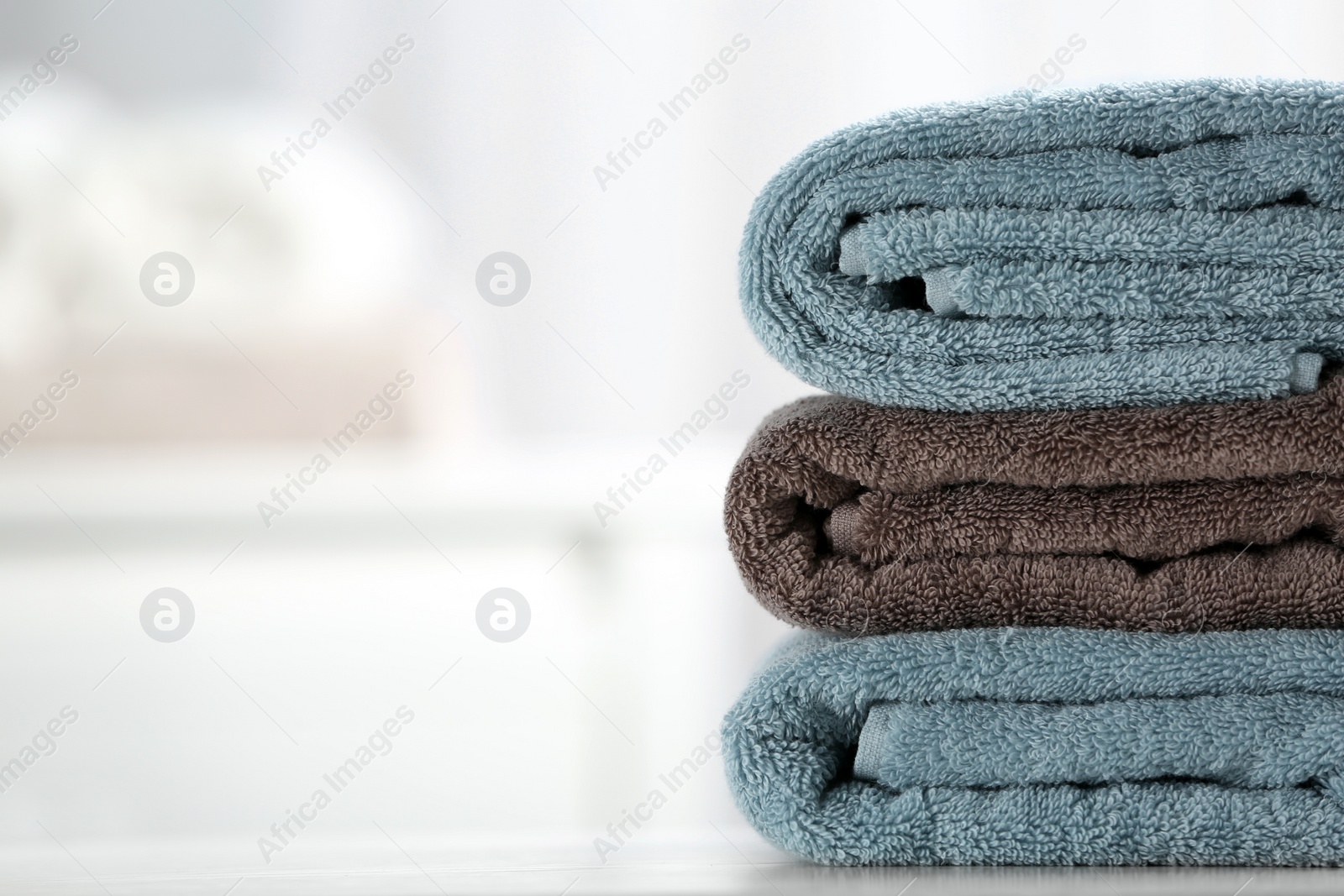 Photo of Stack of fresh towels on table, closeup. Space for text