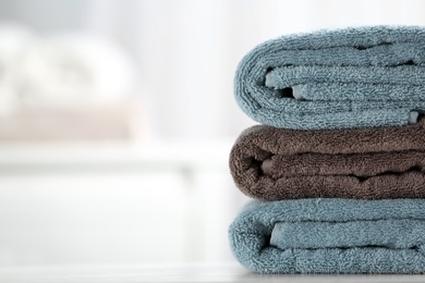 Stack of fresh towels on table, closeup. Space for text