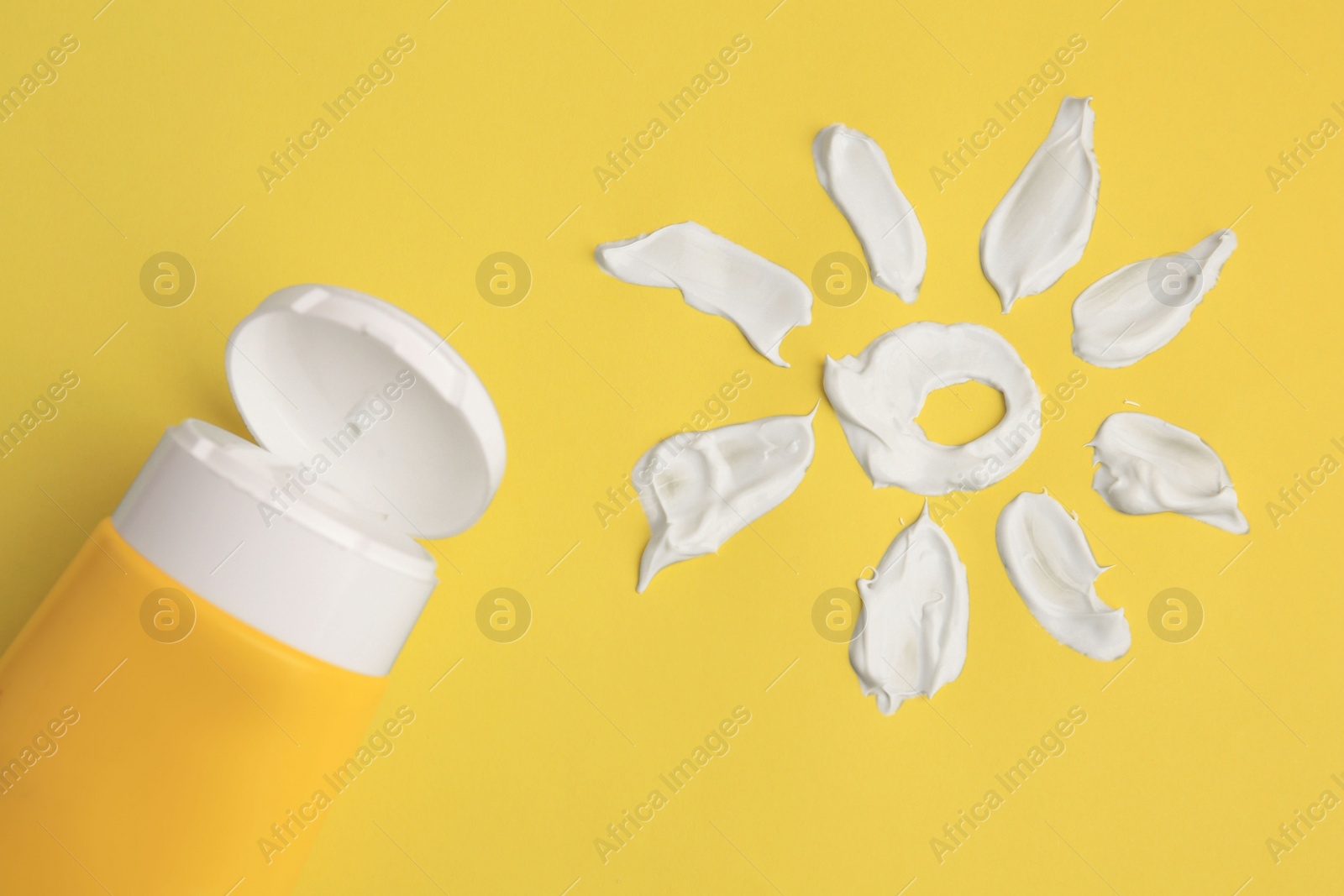 Photo of Drawing of sun and tube with sunscreen on yellow background, above view. Skin protection