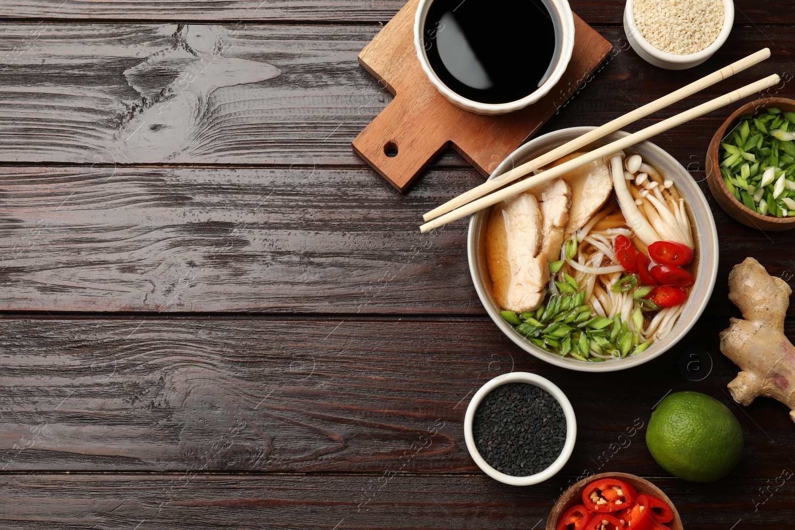 Photo of Delicious ramen with meat and ingredients on wooden table, flat lay. Space for text