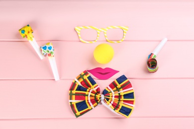 Photo of Flat lay composition with clown's items on pink wooden table