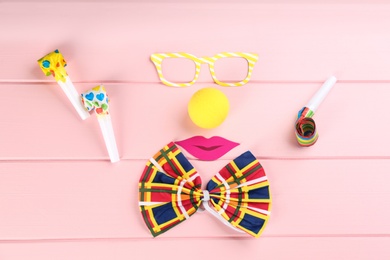 Flat lay composition with clown's items on pink wooden table