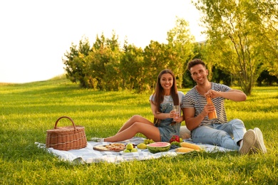 Photo of Happy couple having picnic in park on sunny day