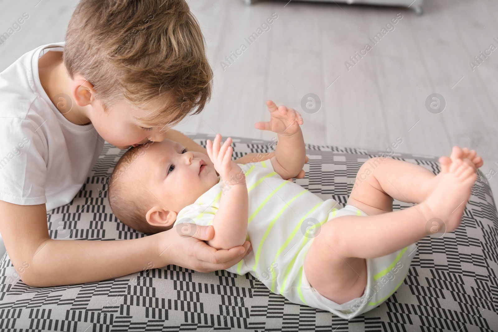 Photo of Cute boy playing with little baby at home