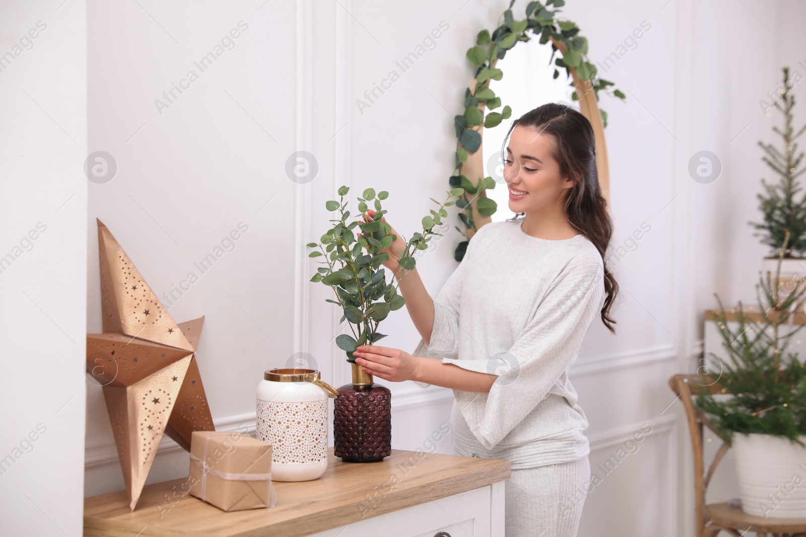 Photo of Woman decorating home interior with eucalyptus branches