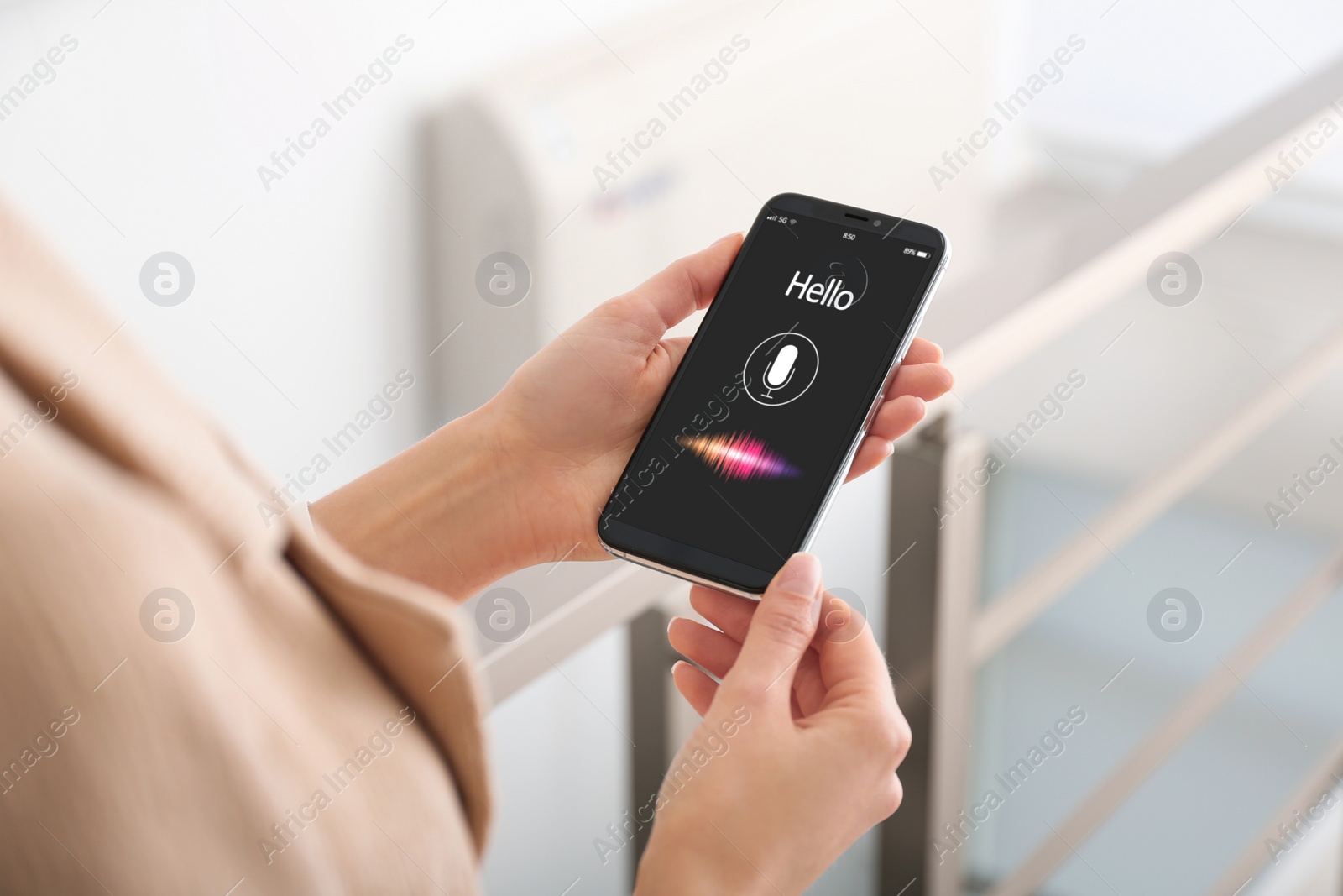 Image of Woman using voice search on smartphone indoors, closeup