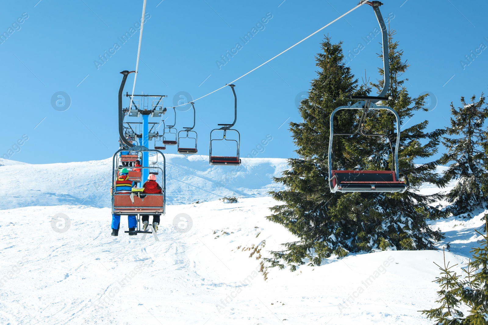 Photo of People using chairlift at mountain ski resort. Winter vacation