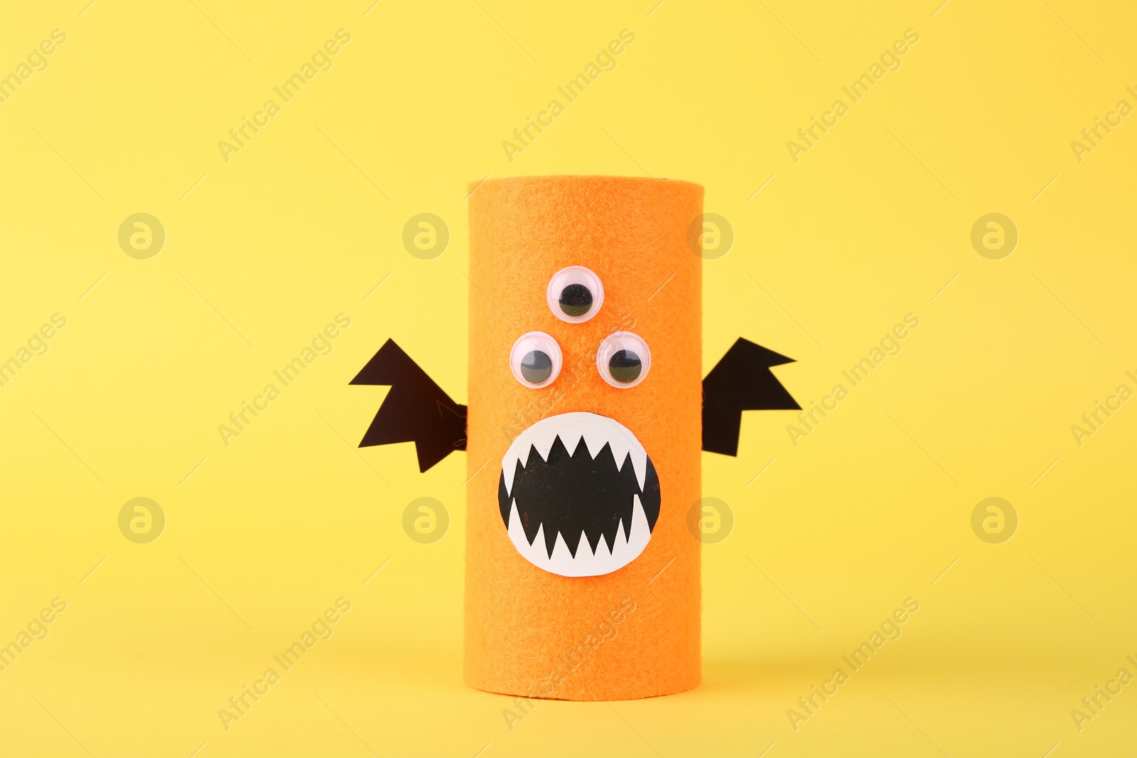 Photo of Spooky monster on yellow background. Handmade Halloween decoration