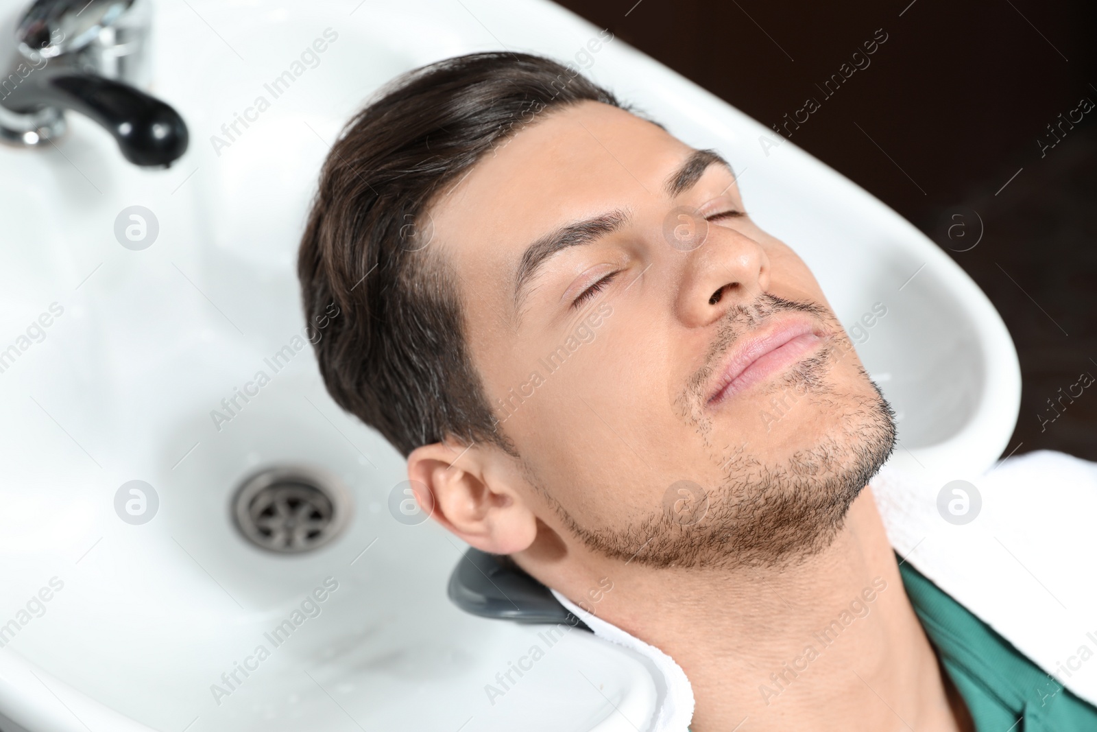 Photo of Man at sink ready for hair washing in beauty salon